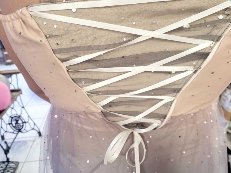 Ajout de tulle pailletée et de flots sur une robe de cérémonie